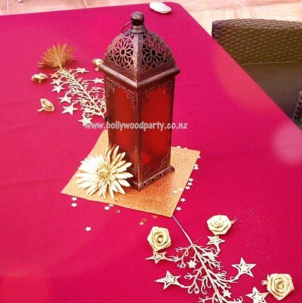 Moroccan lamp centerpiece with intricate metalwork, adding exotic ambiance to event decor.